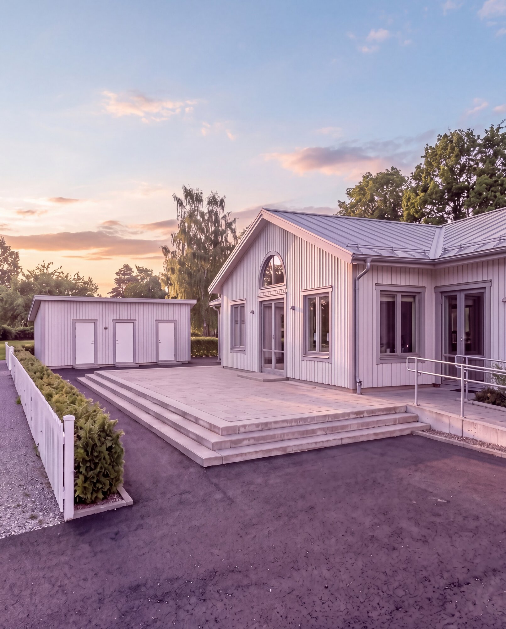 Trygga Hus koncepthus med entréterrass och ramp, fotograferat i solnedgång